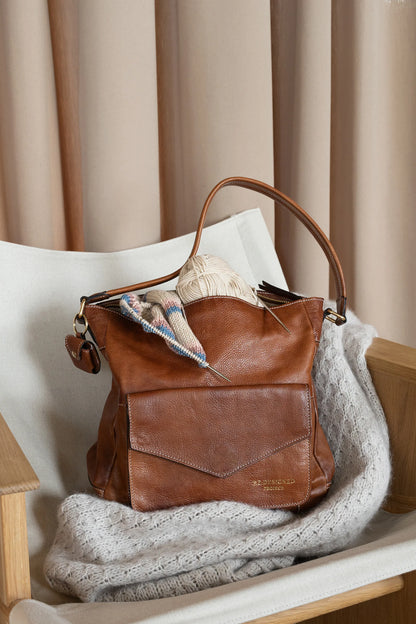 PROJECT 1 est un sac en cuir spacieux pour votre projet de tricot, vos écheveaux de laine et vos accessoires de tricot.

• Comprend une poche avant avec un rabat et un bouton magnétique
• Élégant logo doré
• Poche intérieure zippée et 2 poches ouvertes
• Se ferme avec une fermeture éclair en métal
• Livré avec une bandoulière courte et une longue bandoulière réglable
• Doté d&
